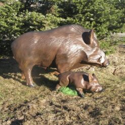 Villisika ja poikanen patsas, metsän reunassa