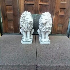 Leijonapatsaat, betonipatsaat pihalle, kuvattu vierekkäin