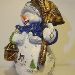 Lumiukko ja luuta kädessä patsas